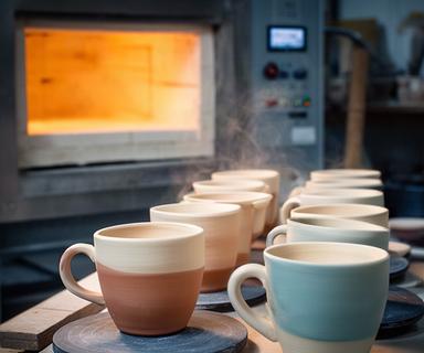 Fila di tazze in ceramica appena uscite dal forno dell
