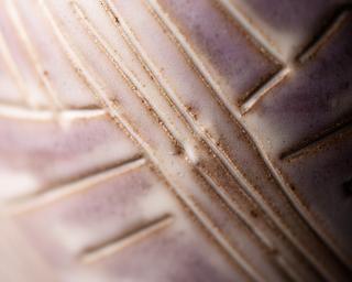 Dettaglio ravvicinato della texture incisa su una superficie ceramica