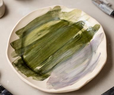 Piatto ceramico smaltato con pennellate verdi e bordo irregolare